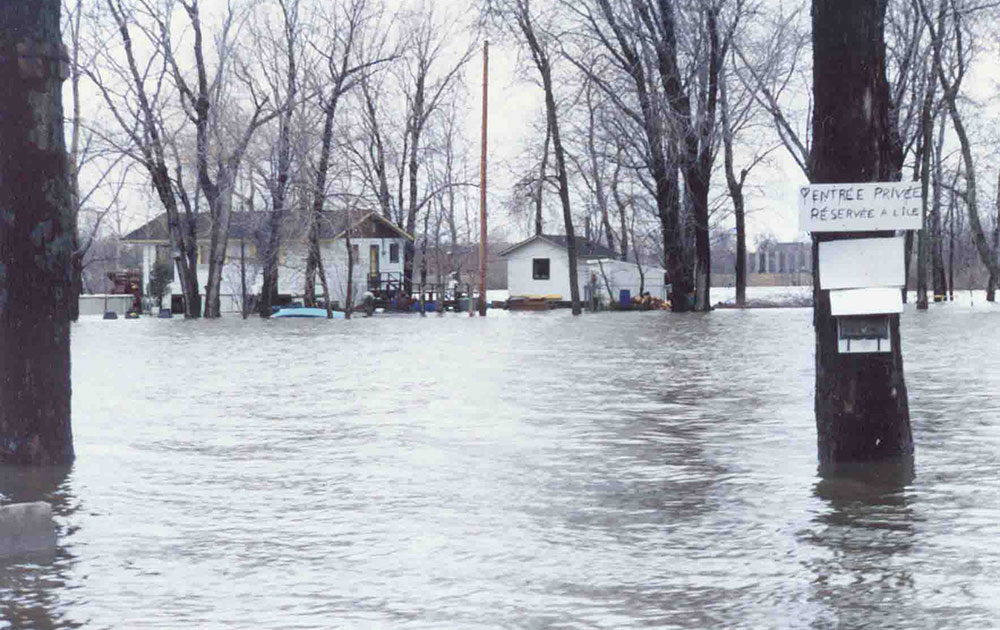 Bâtiments et arbres entourés par les eaux à Laval-sur-le-Lac