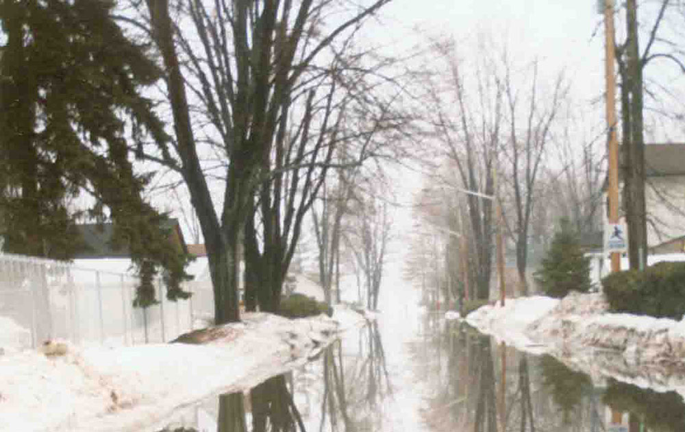 Rue résidentielle inondée à Laval-sur-le-Lac en hiver